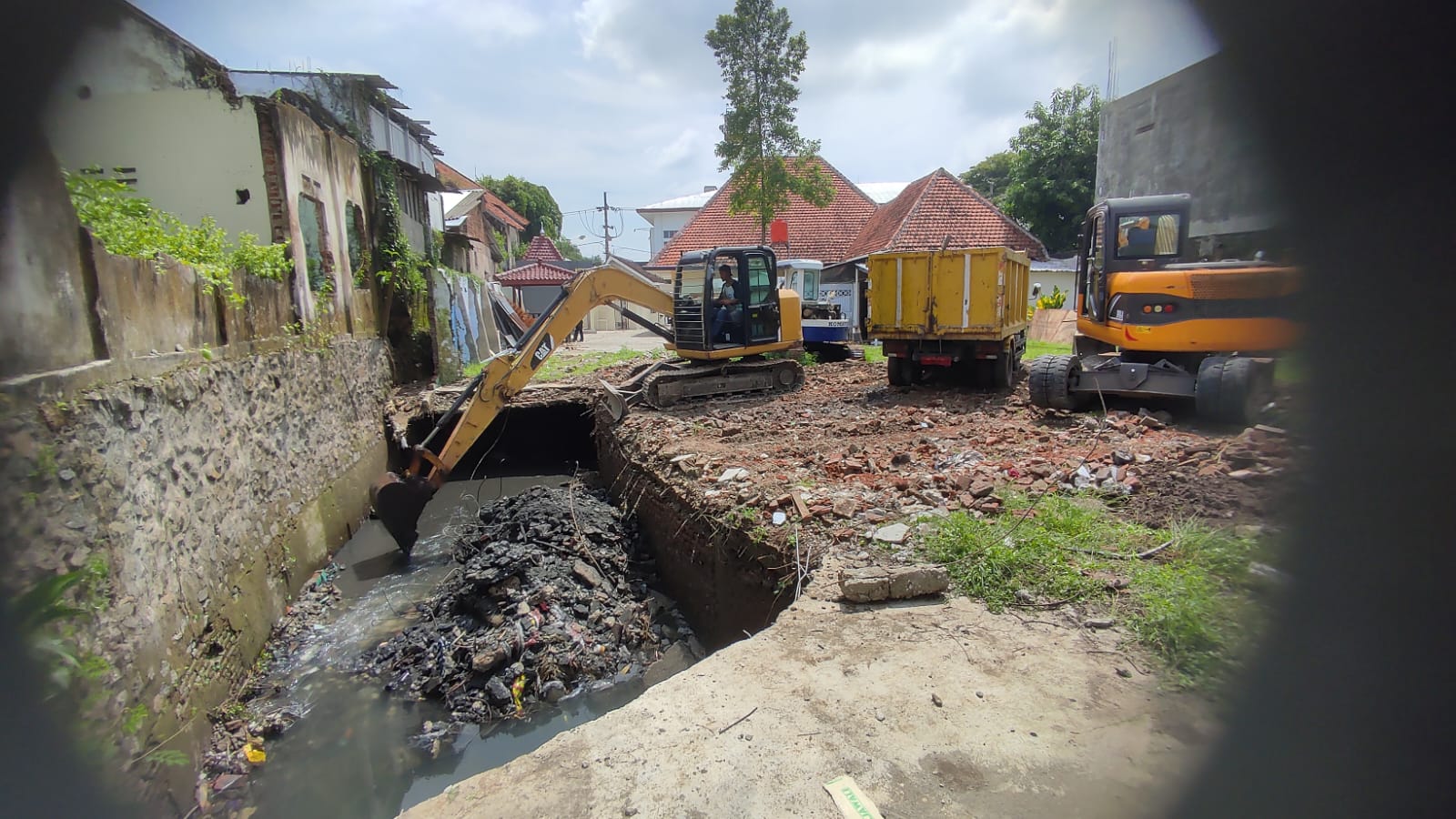 Foto 2 dari 2: Plat Ambrol Di Gang Sendang Sebabkan Genangan Air, Petugas Turunkan Alat Berat Untuk Normalkan Saluran