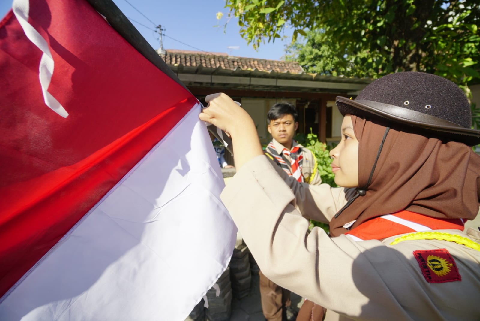 Foto 1 dari 5: Pramuka Kota Madiun Bagikan Ratusan Hingga Ganti Bendera Merah Putih Milik Warga