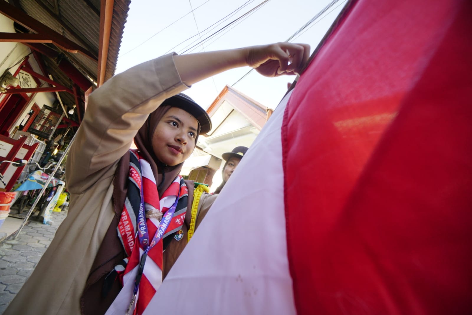 Foto 5 dari 5: Pramuka Kota Madiun Bagikan Ratusan Hingga Ganti Bendera Merah Putih Milik Warga