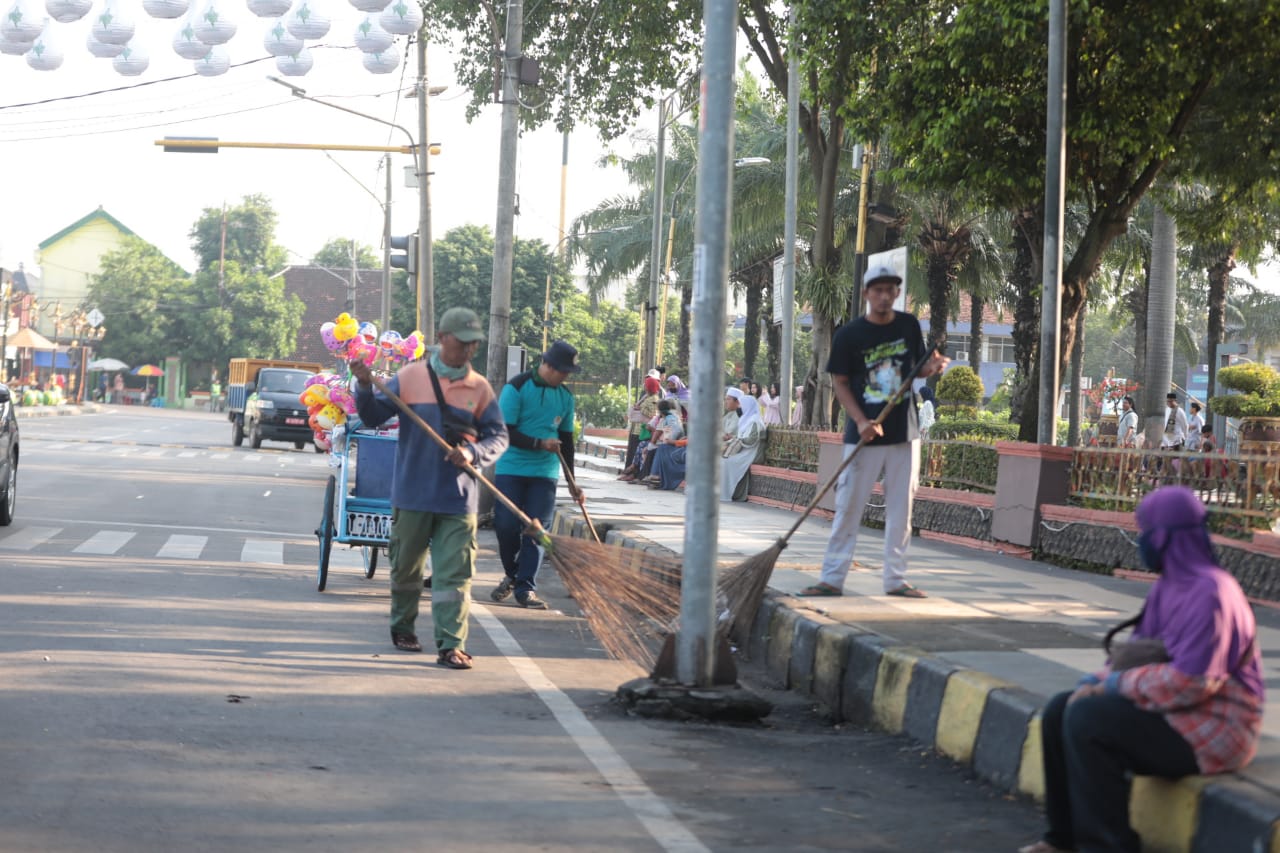 Foto 2 dari 8: Tak Kenal Libur, Petugas Kebersihan DLH Bersihkan Sampah Pasca Salat Ied